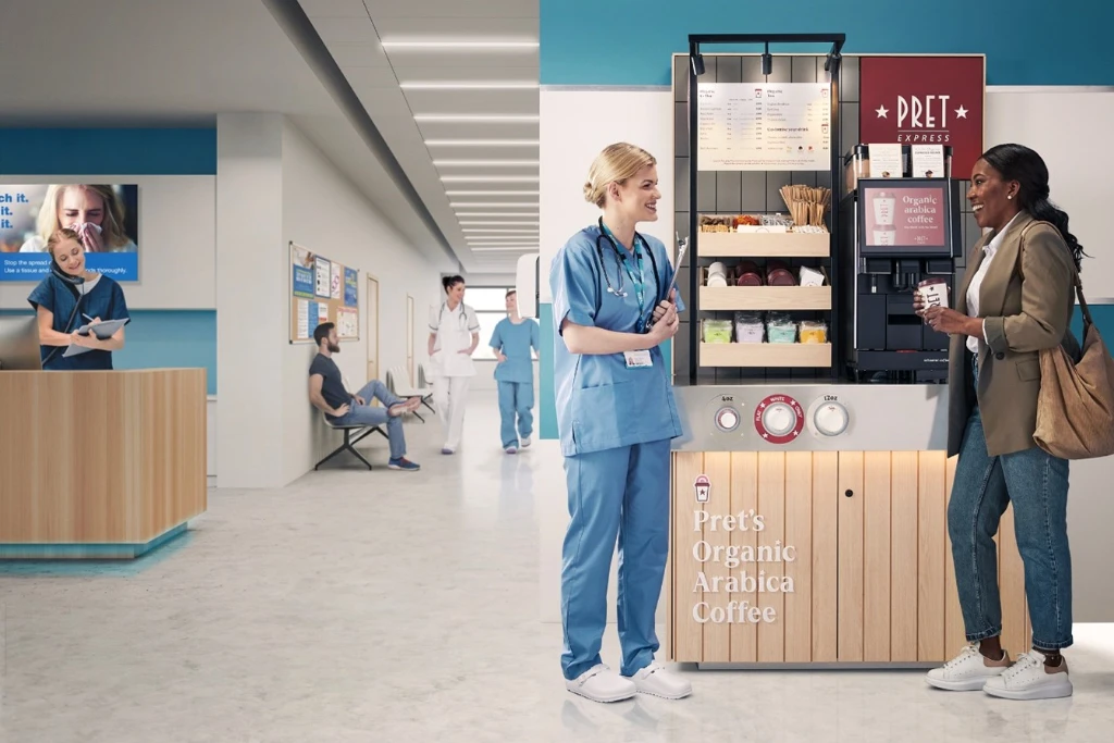 a nurse and a second woman chatting next to a Pret express machine